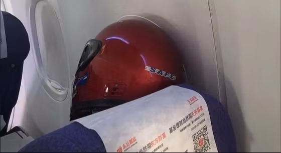 Chiếc mũ bảo hiểm cỡ lớn che kín mặt tuy khá nặng nhưng lại khá đảm bảo, có lẽ sẽ bảo vệ được hành khách này khỏi dịch bệnh.