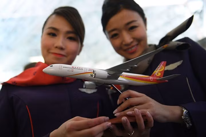 Các nữ tiếp viên của Hong Kong Airlines chụp ảnh cùng mô hình máy bay của hãng./.