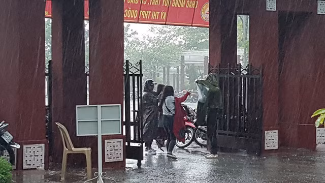 Những chiếc áo mưa đưa cho thí sinh để các em trùm vào người chạy vào phòng thi.