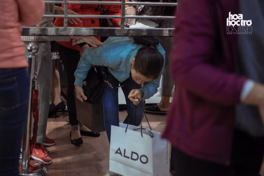 Khách phải luồn khe cửa để được mua hàng ngày Black Friday.