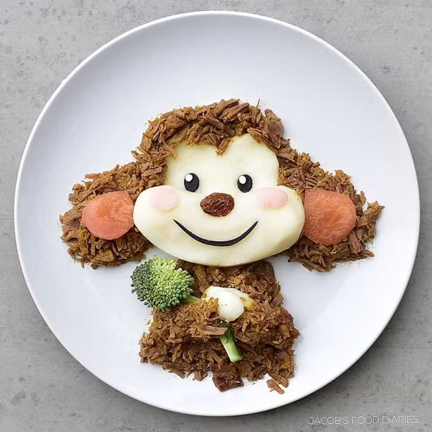 Một chú khỉ đáng yêu được làm từ thịt bắp cừu om xé nhỏ, một chút khoai tây, cà chua và súp lơ