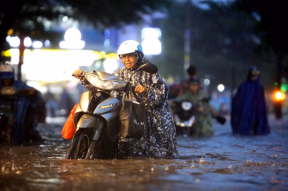 Đường Nguyễn Hữu Cảnh ngập sâu khiến nhiều xe máy bị tắt máy, người dân phải dắt bộ. ẢNH: NGỌC DƯƠNG.