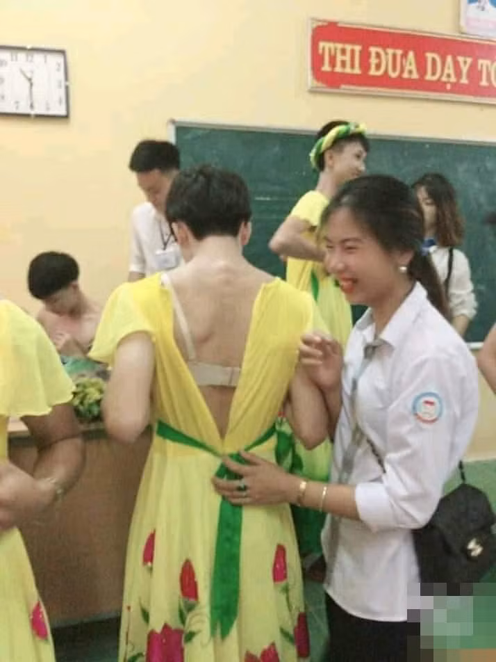 Các bạn nữ tận tình giúp các bạn nam mặc trang phục.