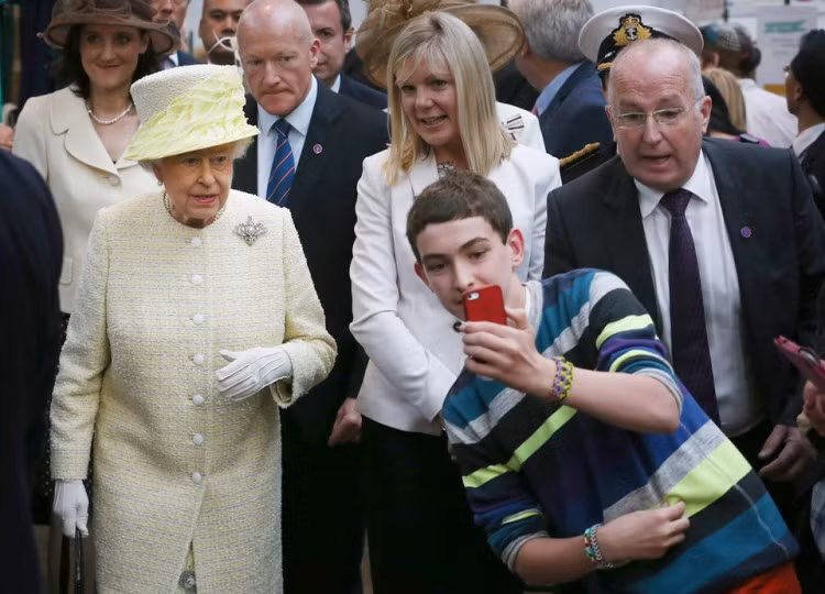 Dù không có hứng chụp ảnh cùng nhưng Nữ hoàng Elizabeth vẫn niềm nở chụp một tấm selfie với người khác.