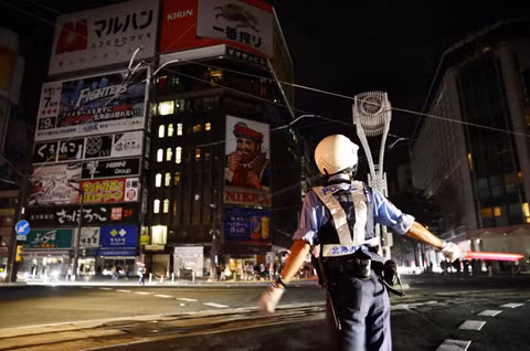 Cảnh sát phải điều tiết giao thông ở Sapporo vì đèn đường không hoạt động. Ảnh: REUTERS.