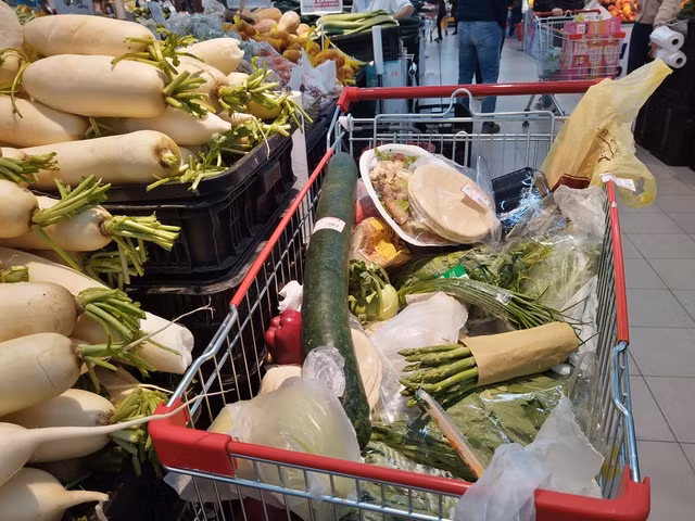 Một số người mua rất nhiều các loại rau,củ... chất đầy một xe đẩy trong siêu thị.