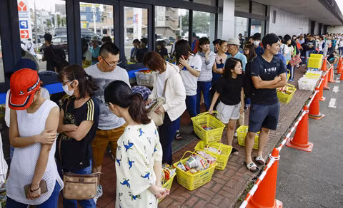 Người dân xếp hàng chờ mua thức ăn bên ngoài một cửa hàng ở Sapporo. Ảnh: REUTERS.