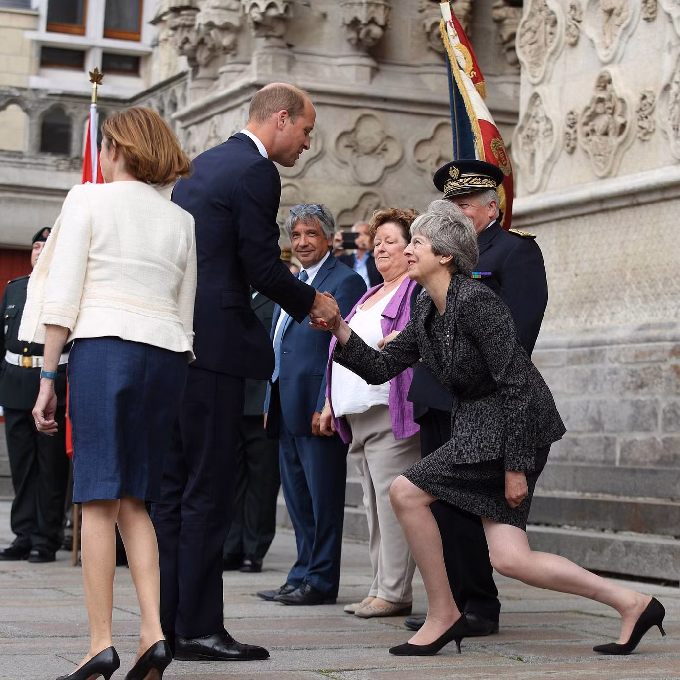 Thủ tướng Anh Theresa May khom người, khuỵu gối cúi chào Hoàng tử William tại lễ kỷ niệm 100 năm trận đánh nổi tiếng Amiens trong Thế chiến I tại Nhà thời Amiens, Pháp. Ảnh do phóng viên PA Yui Mok chụp.