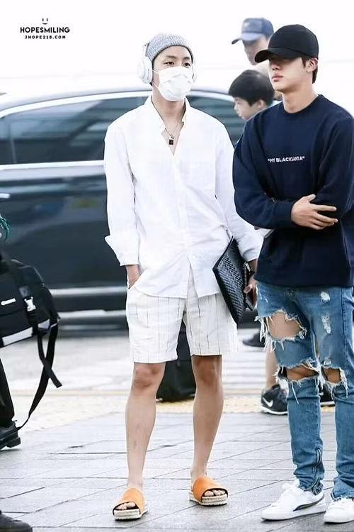 J-Hope có thể biến vẻ ngoài tưởng như đơn giản thành một diện mạo bắt mắt nhờ những chi tiết nhỏ như tai nghe, sandals, vòng cổ...