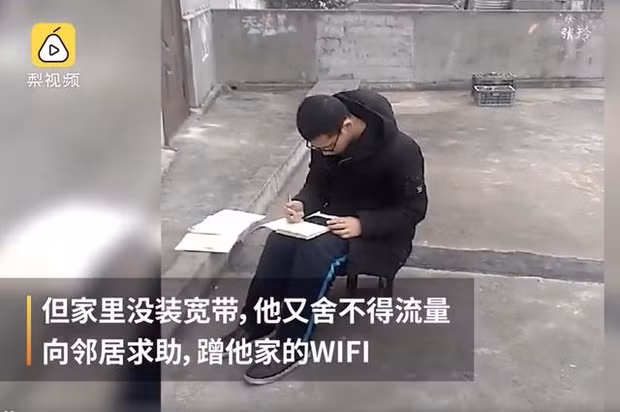 Chàng trai 18 tuổi chăm chú ngồi học giữa trời lạnh.