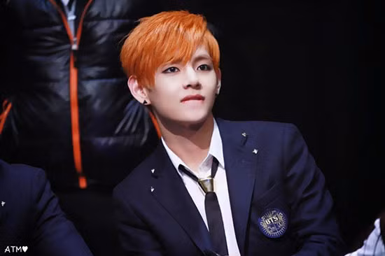 Năm 2014 là thời điểm BTS mới debut được một năm, và V nhìn như một cậu học trò cá tính và nổi loạn với tóc nhuộm màu cam rực rỡ, kẻ viền mắt rất đậm.