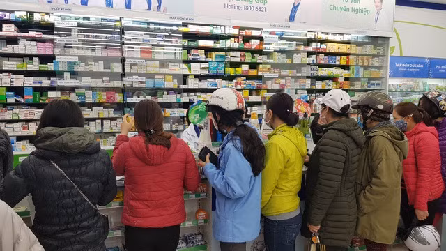 Trong quầy thuốc vô cùng nóng nực và khó thở vì có tới hàng chục người đứng trong xếp hàng chờ mua khẩu trang.