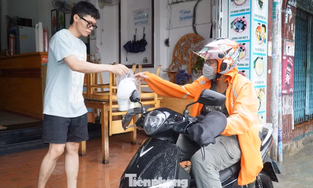 TPHCM ngập sâu, shipper chật vật 'đạp sóng' giao cơm cho khách