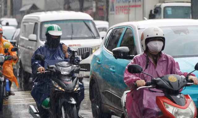 Mưa lớn giữa trưa ở TPHCM, dòng người và xe 'nhích từng chút' 