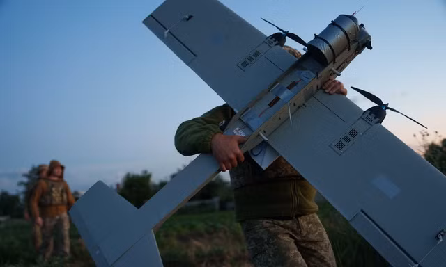Binh sĩ thuộc Lữ đoàn K-2 của Lực lượng Hệ thống không người lái Ukraine đưa chiếc UAV tầm trung vào vị trí chiến đấu Ảnh: AP