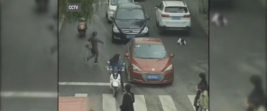 Em bé ngã sấp mặt lọt gầm chiếc xe màu trắng.