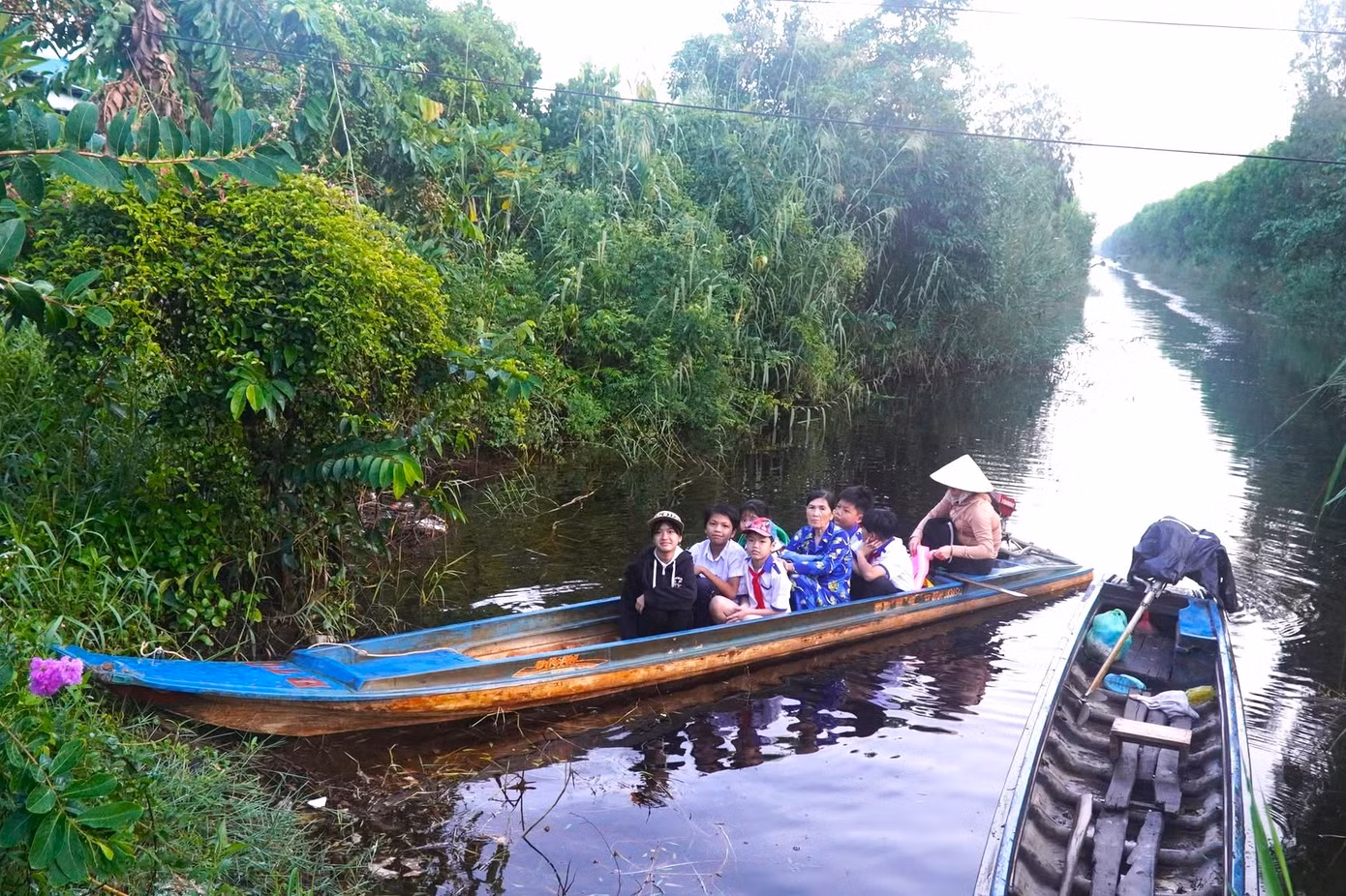 Nhiều em học sinh phải đi xuồng máy ra điểm chính dự lễ khai giảng năm học mới.