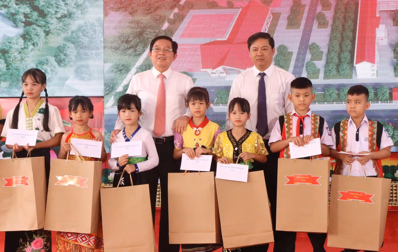Phó Thủ tướng Chính phủ Hồ Quốc Dũng (bìa trái), cùng Bí thư Tỉnh ủy Đắk Lắk Lương Nguyễn Minh Triết, tặng quà cho các em học sinh.