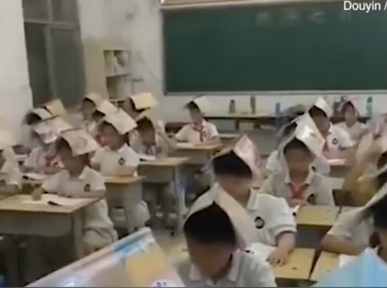 Học sinh Trung Quốc đội sách lên đầu để “tránh tư thế ngồi xấu” gây tranh cãi nảy lửa ảnh 1