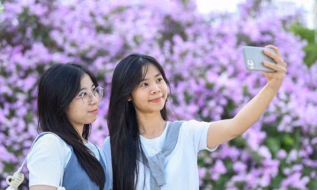 Giới trẻ đứng kín cầu đi bộ chụp ảnh check-in cây bằng lăng gây sốt ở Hà Nội