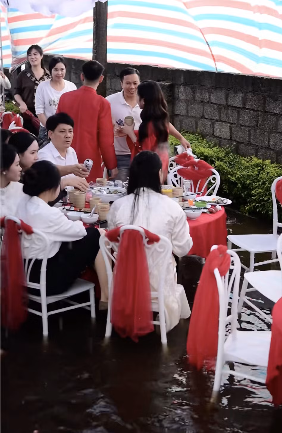 Quan khách cùng dâu rể xắn quần, co chân ngồi ăn cỗ.