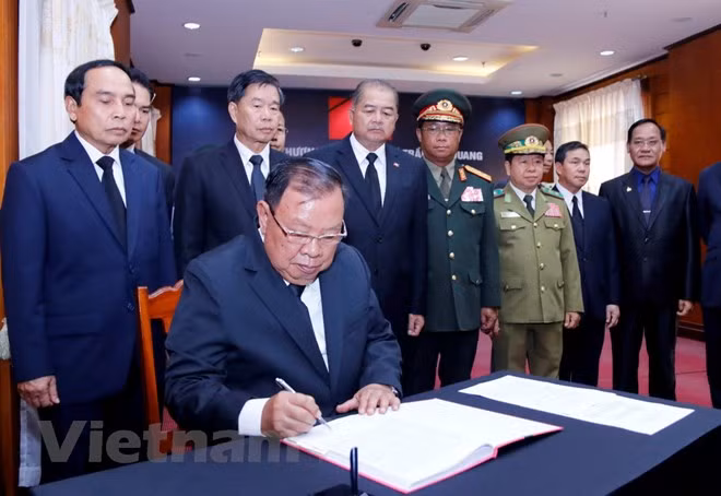 Tổng Bí thư, Chủ tịch nước Lào Bounnhang Vorachith ghi sổ tang tại lễ viếng Chủ tịch nước Trần Đại Quang. (Ảnh: Phạm Kiên/Vietnam+)