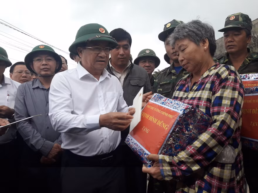 Phó Thủ tướng Trịnh Đình Dũng tặng quà cho người dân thôn Hải Nam, xã Nhơn Hải. Ảnh: Tr.Định
