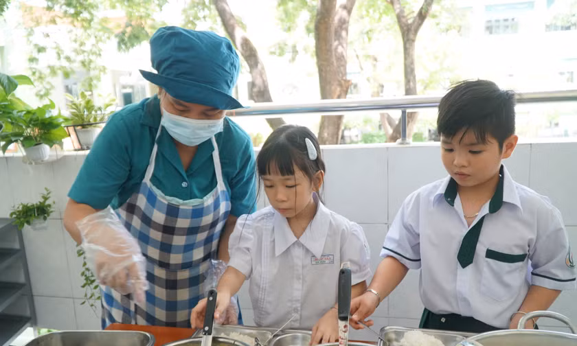 Theo bà Nguyễn Thị Minh Nguyệt, Hiệu trưởng Trường Tiểu học Hiệp Tân, sau sáp nhập, quy mô trường lớn hơn, lại có hai điểm trường nên phương án tổ chức bếp ăn cũng được điều chỉnh. Thay vì tự thực hiện các khâu từ mua thực phẩm đến chế biến như trước, trường thuê một đơn vị bên ngoài đảm nhận hoạt động bếp.