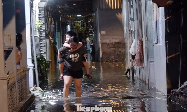 Nước tràn vào nhà, người dân TPHCM tất tả đắp bao cát 'chạy' ngập