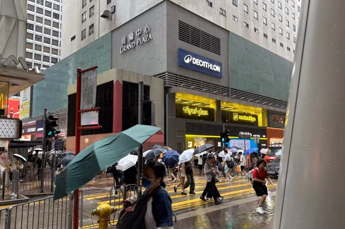 Người dân ở Hong Kong đi dưới mưa to và gió do ảnh hưởng của bão Noul